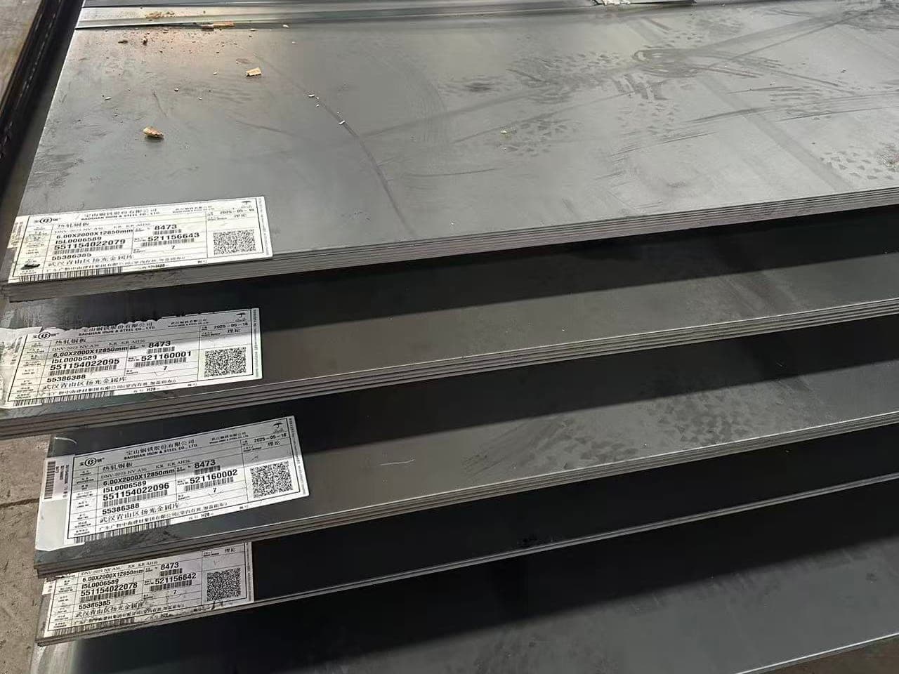 Heat number and grade labels attached to shipbuilding steel plate in stock